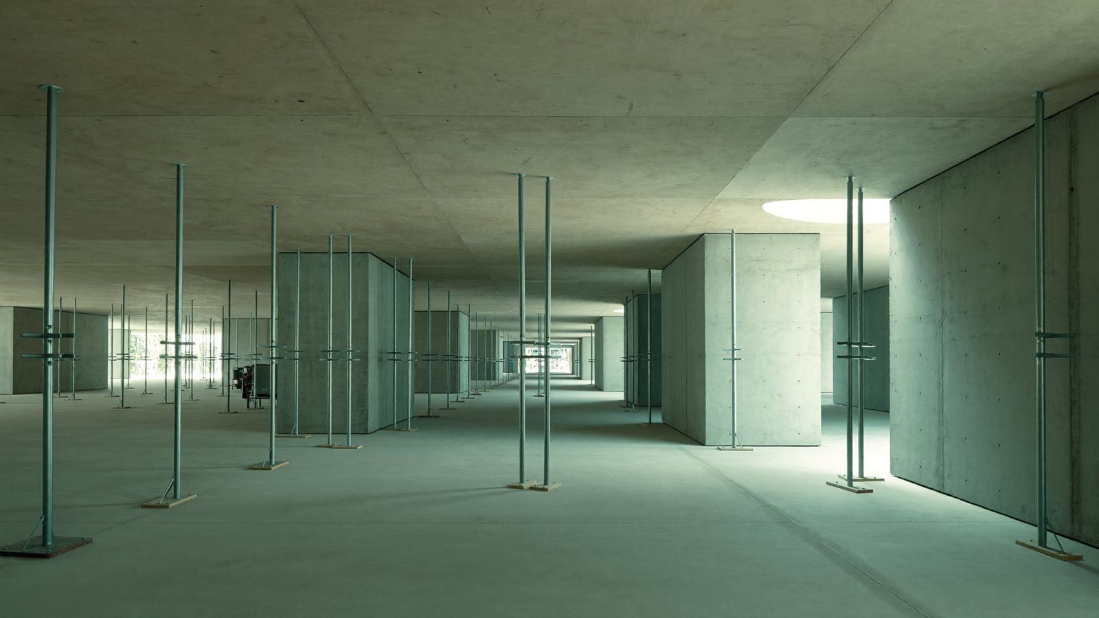 A completed suspended slab level with steel props and concrete walls receding toward the open perimeter edge